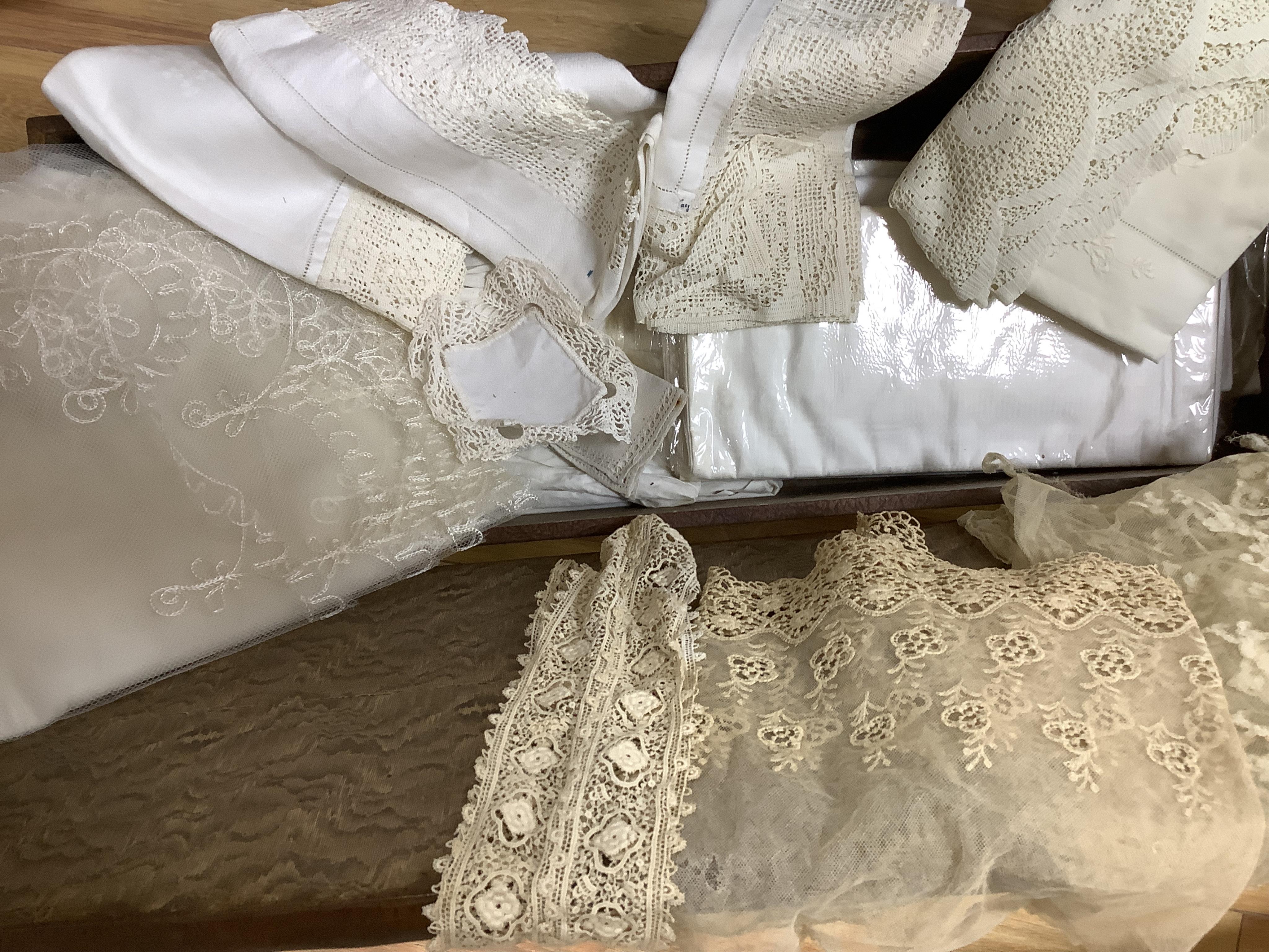 A small box/trunk containing mixed crochet, embroidered anglaise and drawn thread table linens, christening gown, damask cloths and various pieces of lace etc.Ornate circular cloth 112cm diameter. Condition - most need r